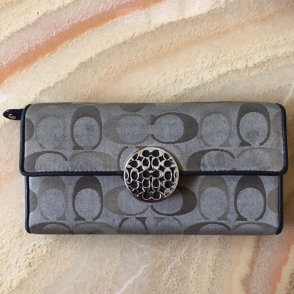Brown Coach logo tri-fold wallet.